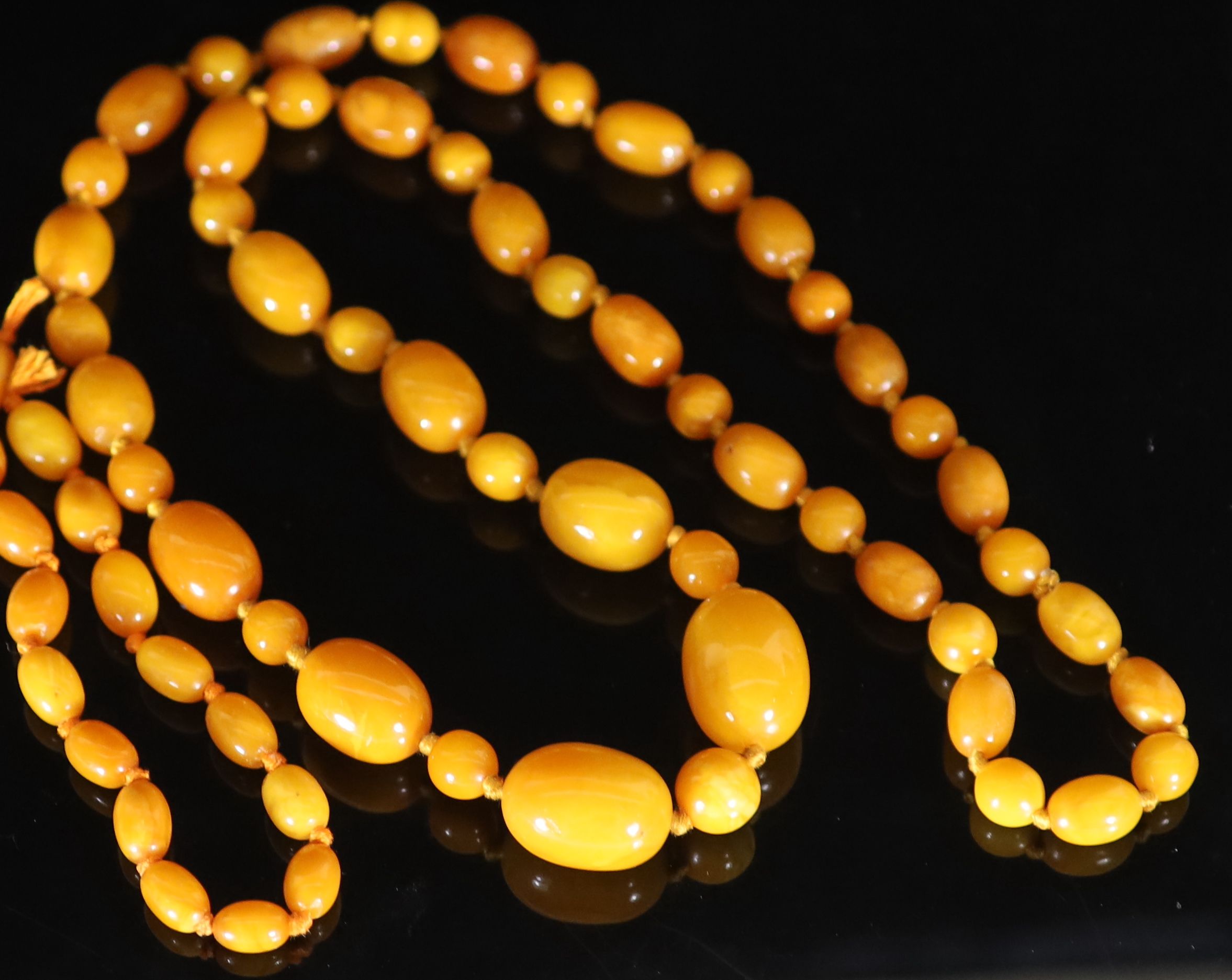 A single strand graduated oval amber bead necklace with round bead spacers